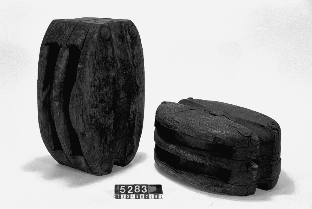 Dubbelskivigt block av trä med stropp av hamptross och krok av järn. Vikt på det större blocket: 9.8kg Diameter: 240mm, bredd: 175 mm, höjd: 350 mm.