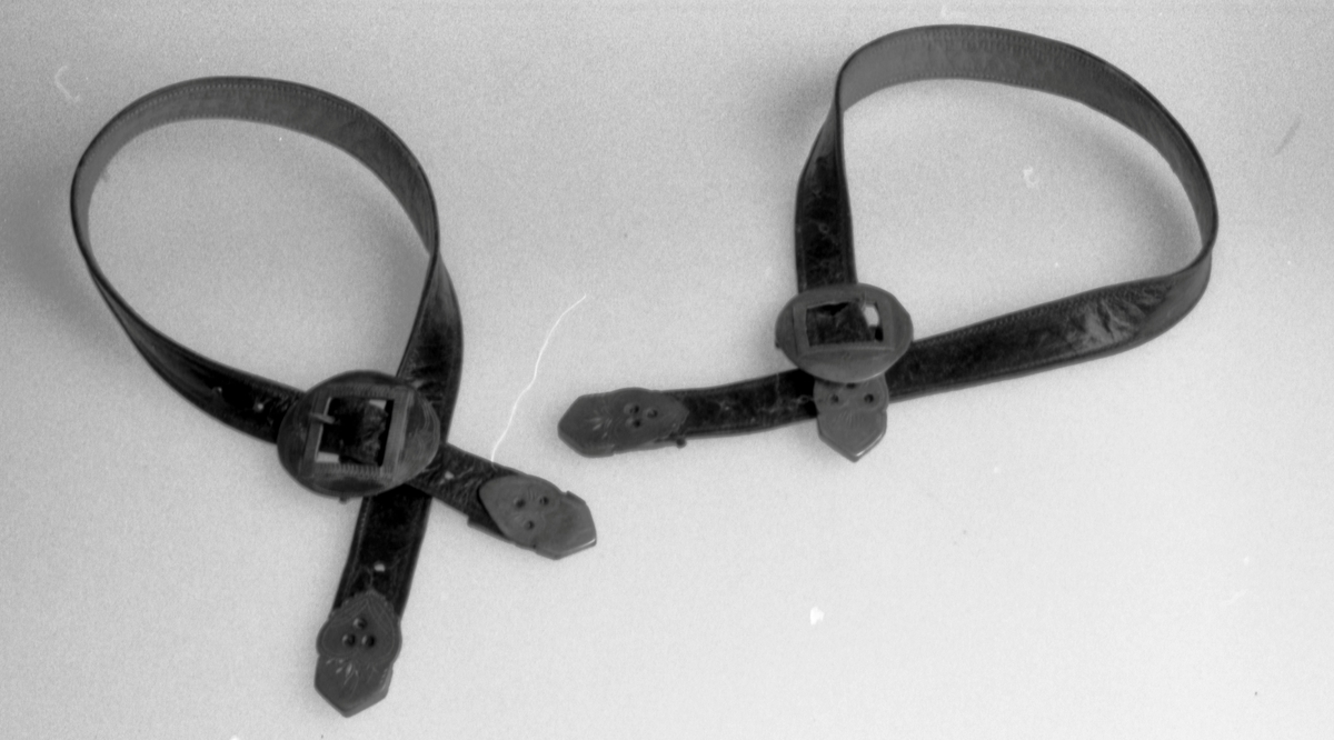 "Sprett og sprota" til å holde strømpene oppe. Lærremmer med sølvspenner og sølvtupper i endene. Den ene spennen er en kopi laget i tynnere materiale.