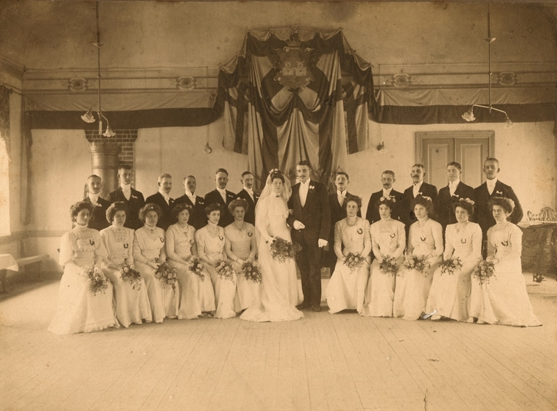 Bröllopsfoto, gruppbild, interiör, brudpar med 11 herrar och 11 damer(alla damer klädda i vitt) Andersson dotter, 4st, gåva av fru Stillén, 67:1025.