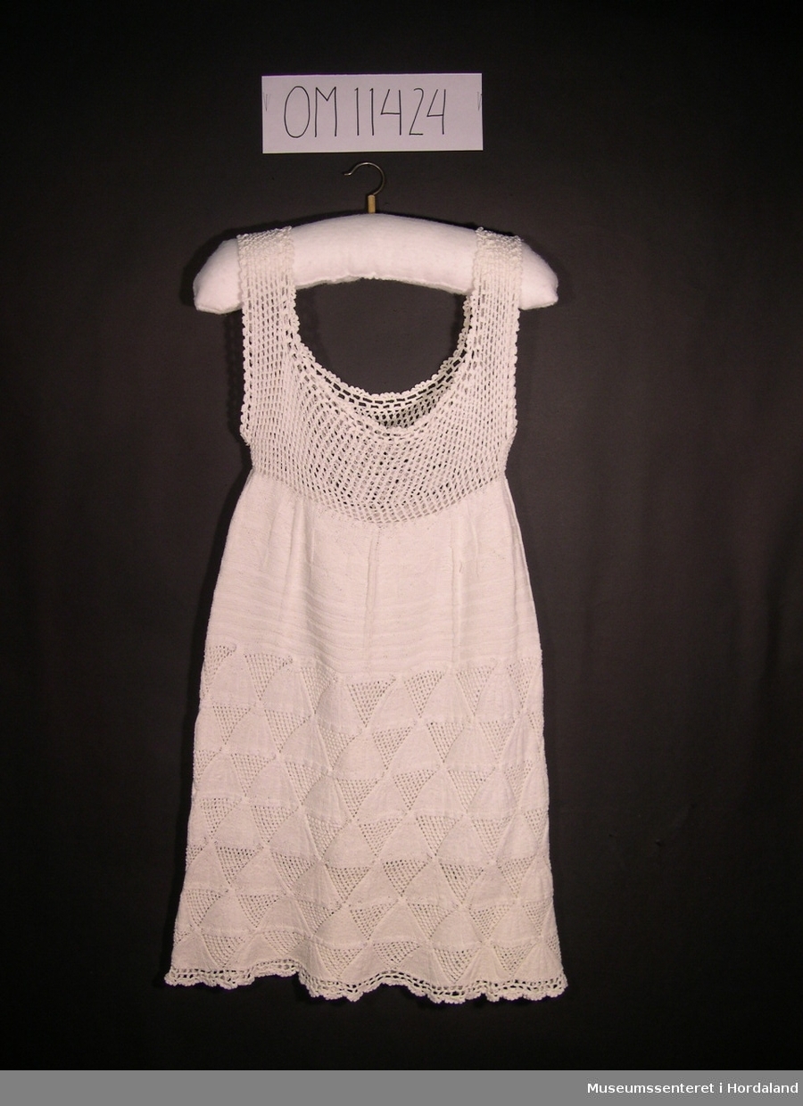 Form: skrådd kjole med breie, hekla skulderband og  mønsterstrikk
