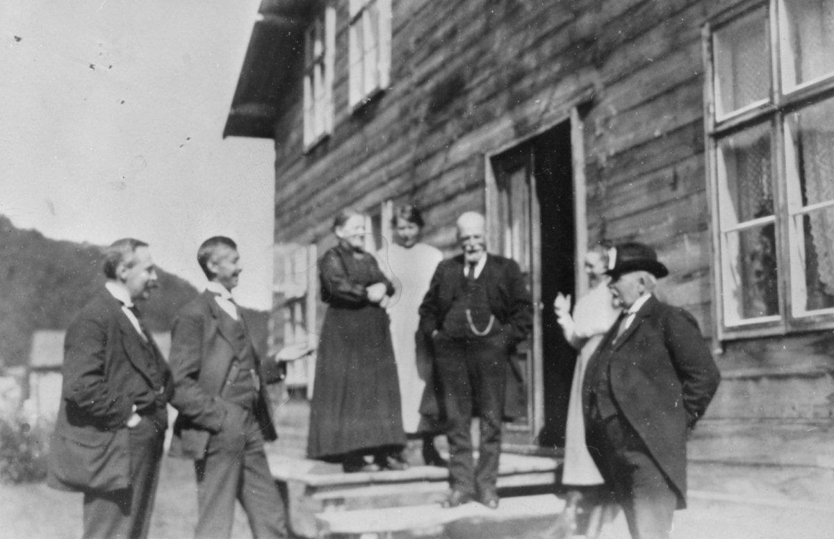 Bildet er tatt i Neiden omkring 1920. Det er sendt som takke- kort til skolestyrer Reinholdsen fra bokhandler Toralv Hagen. Gruppebilde med fire menn og to kvinner. Kvinnene er kledt i kjoler, mennene i dresser.