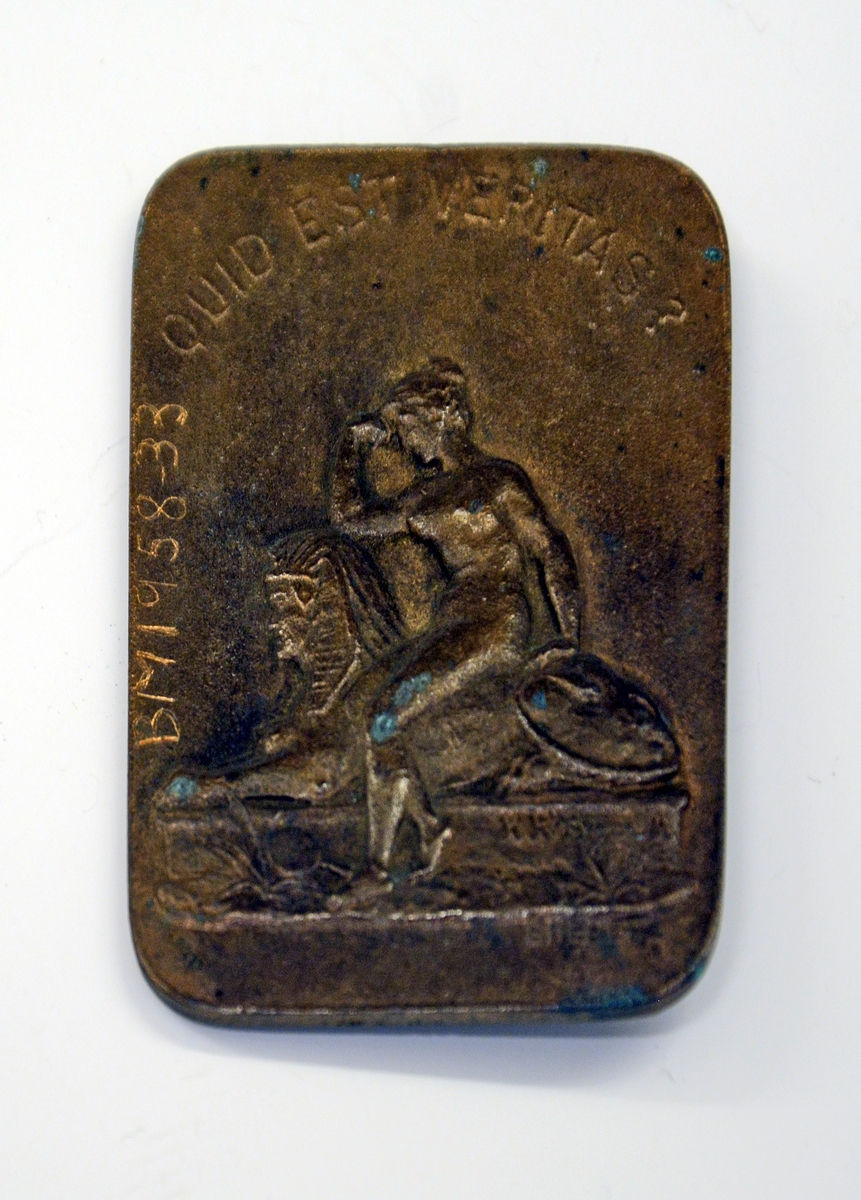 Fra protokollen: 
Portrettmedalje av bronse som på forsida viser "Dr. Henrik Ibsen", på baksida naken kvinne på kentaur, innskr. "Quid est veritas?". Medaljen har rektangulær form med avrunda hjørne. Den er laget av H. R. Bruun (1854-1929) i 1895.