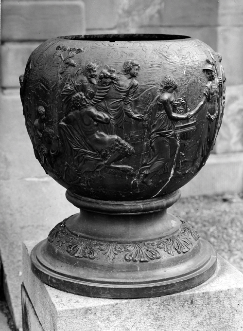 Urnan är prydd med reliefer framställande mytologisk scen.