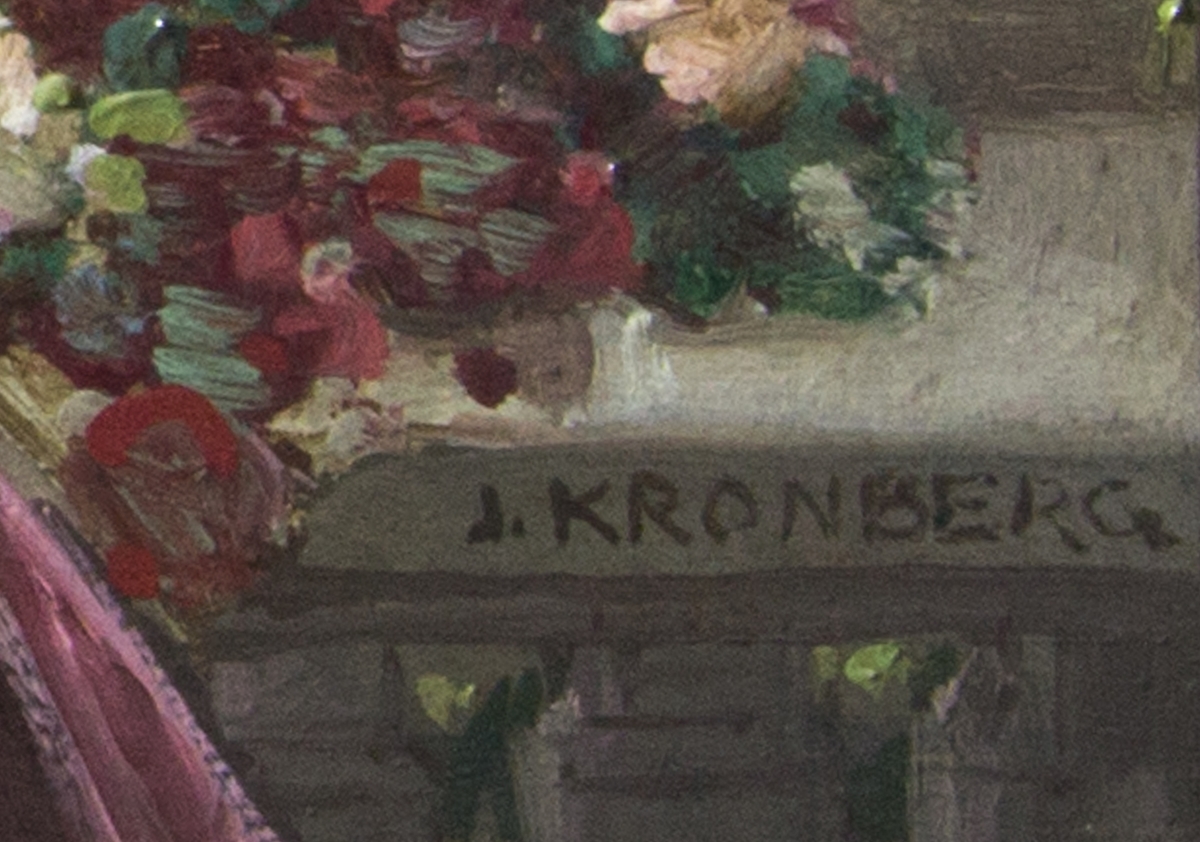 Ung kvinna sittande på en veranda klädd i rosa klädnad med ryggen mot åskådaren. Framför henne ett bord med blommor och en korg med blommor. Kvinnans ena hand vilar på korgens handtag. I bakgrunden träd och sjö.
