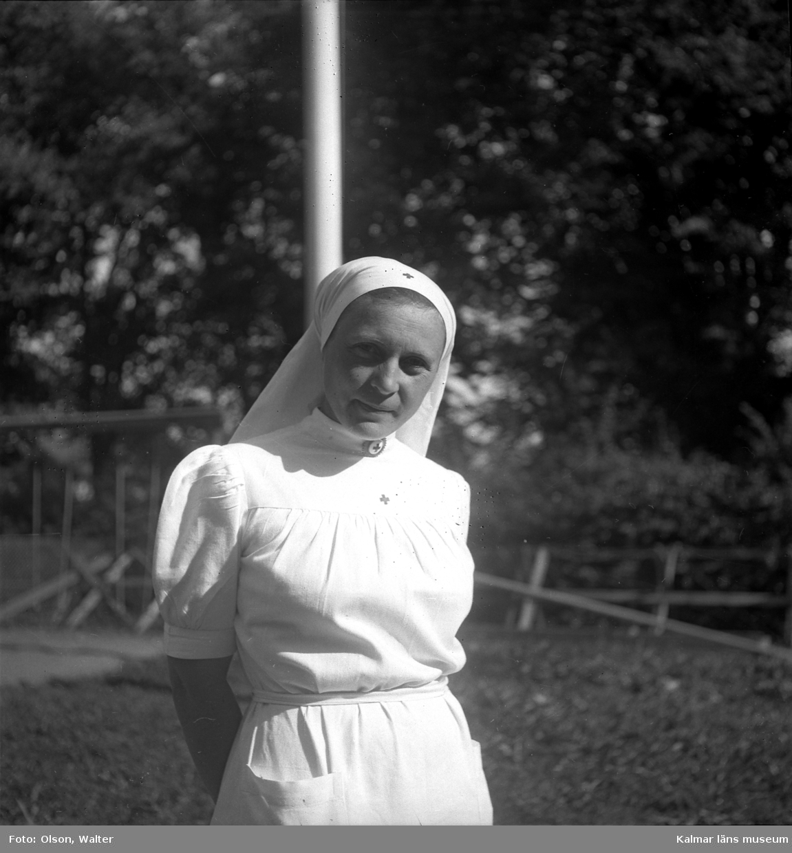 Sköterska på Beredskapssjukhuset vid flaggstången.