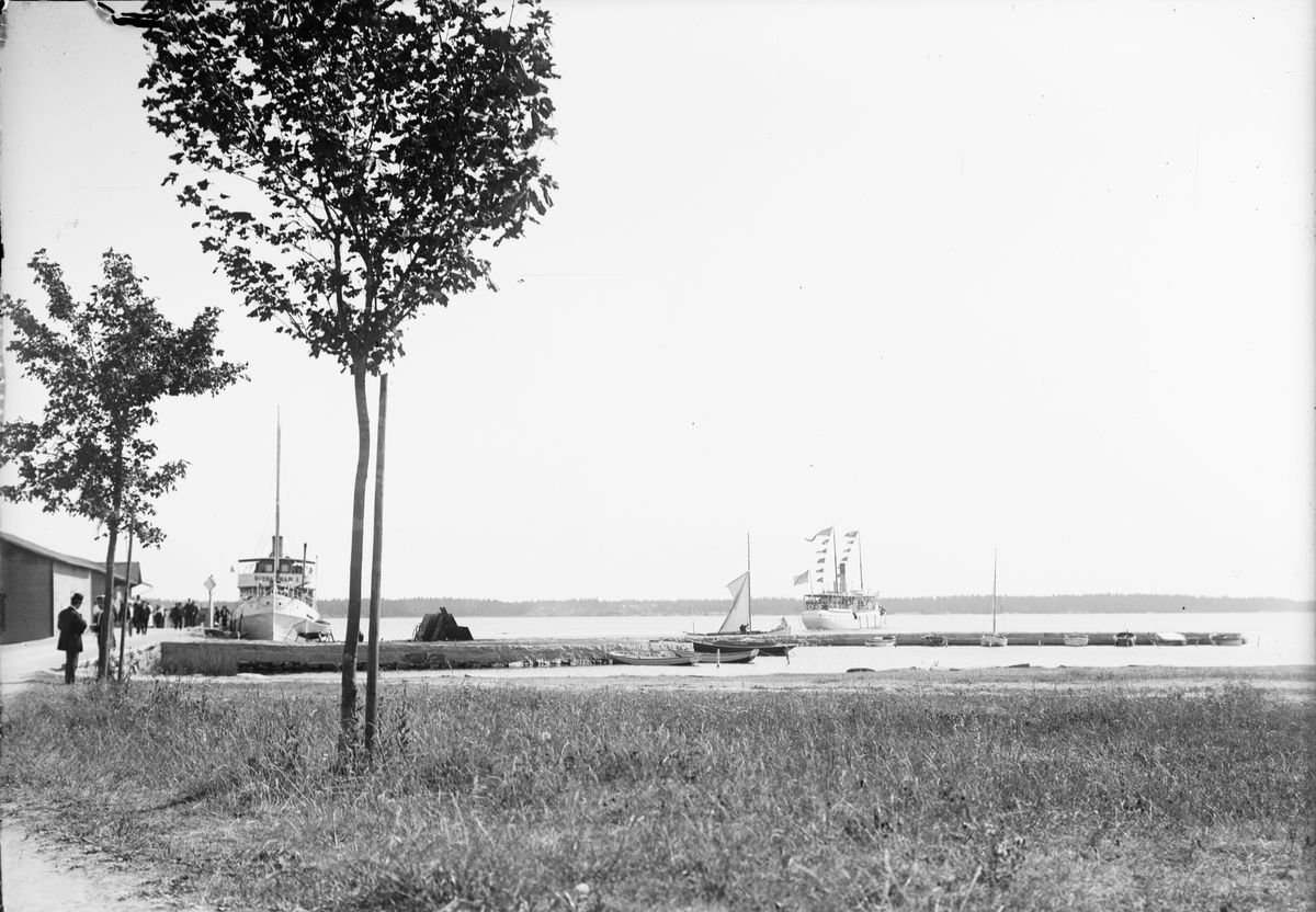 Ångfartygen Östhammar I vid kajen och Östhammar II med flaggspel (stor flaggning), på utgående, Östhammar, Uppland
