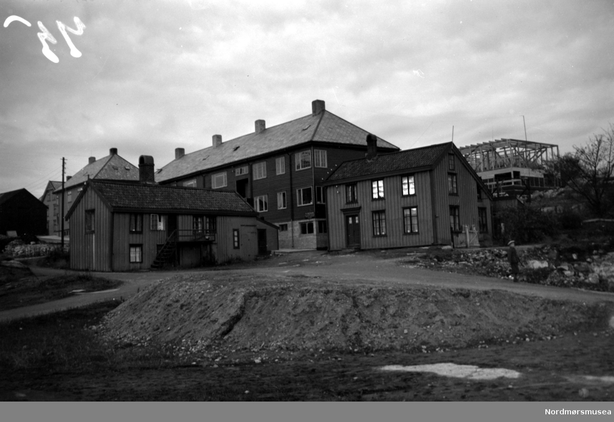Bygninger i Politimester Bendixens gate/Tollåsenga med to hus av den eldre bebyggelse som "overlevde" tyskernes bombinger i slutten av april 1940. Bildet er datert November 1940. Nordmøre Museums bildesamling