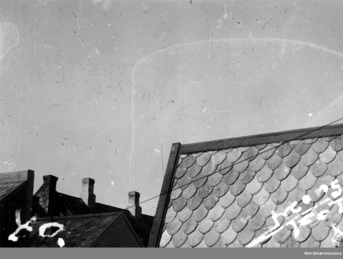 "Dødningen". Dødsringen "Dødningen". Signalet til bombardementet av byen utført av tyskerne tidlig søndag morgen, den 28. april 1940. Dette var starten på slutten av det gamle Kristiansund ; De neste dagene, frem til ca. 1 mai 1940 ble byen totalt rasert til det ugjenkjennelige. Bildet er stemplet Monge foto. Fra Nordmøre museums fotosamlinger.