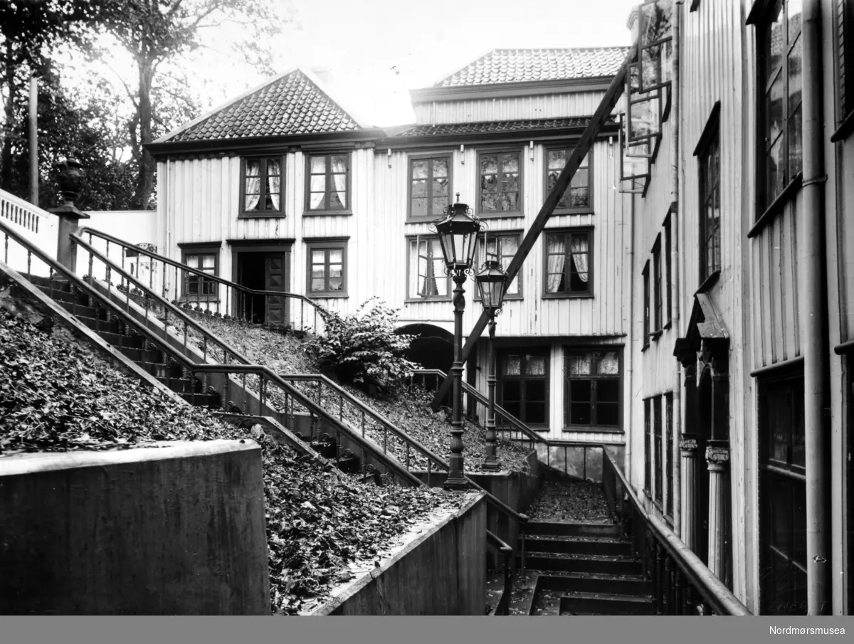 Foto fra Knudtzongården som lå i Storgata på Kirkelandet i Kristiansund. Her ser vi trappen som leder ned til bygningen. Fotograf er Anders Beer Wilse, og datering er trolig omkring 1930. Fra Nordmøre Museums fotosamlinger.