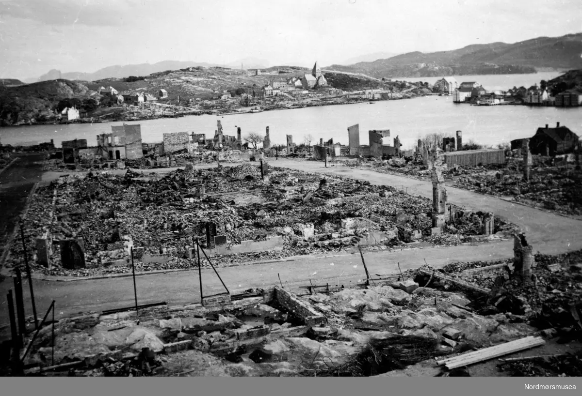 Foto fra et utslettet Kristiansund, hvor vi ser fra ruinene på Kirkelandet i front og med ruinene på Nordlandet på andre siden av havnebassenget. Bildet kan dateres til engang etter 28. april 1940, som var starten på tyskernes bombing av byen. Fra Nordmøre museums fotosamlinger.



