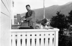 Foto av en mann på en veranda, med hund, platespiller og pip