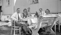 Foto trolig av et teselskap ute i hagen,
 trolig hos Georg o