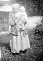 Foto av en ukjent kvinne med et barn på armen, trolig i Vist