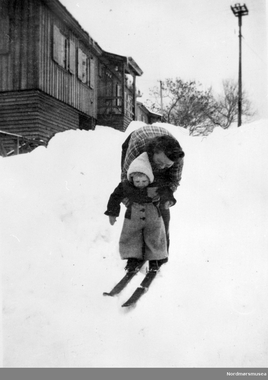 Barn på ski, mor, brakke, Kristiansund ca 1947, snø. 

 Fra Nordmøre Museum sin fotosamling.