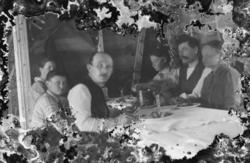 Foto av en familie sittende rundt et middagsbord. Det er ukj