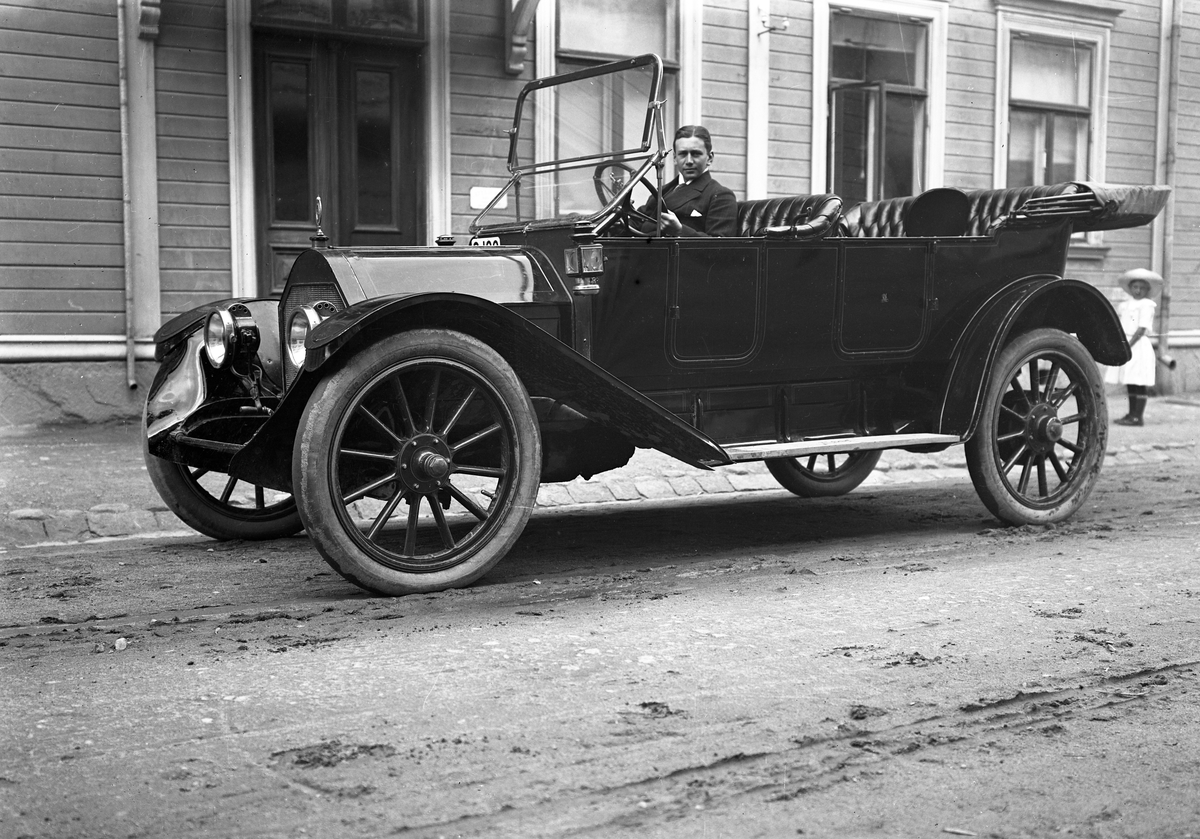 Olle Andersson i en bil av märket  Nyberg 40Hp (Model 4-40) 7-Passenger Touring 1913 
Bilden är tagen utanför Karl Nyströms ateljé på Södra Klaragatan 2.