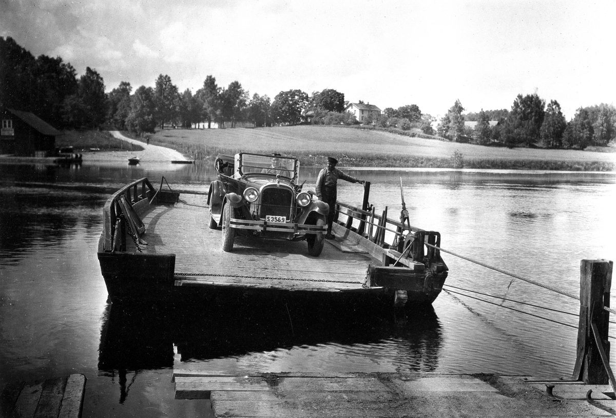 Högsäters färja över Byälven vid nuvarande väg 175. Redan 1710 förekom transporter över Byälven vid Högsäter och den finns kvar än idag och är dessutom den sista återstående vägfärjan i Värmland. Bilen är en Dodge Touring från 1925 och ägdes då av Gustaf Warolin i Säffle.