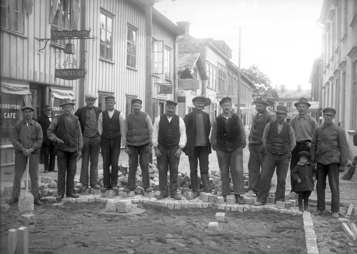 Stenläggning av Drottninggatan i Filipstad på en bild från runt 1910. Fotografen drev en ateljé mellan 1904 och 1947.