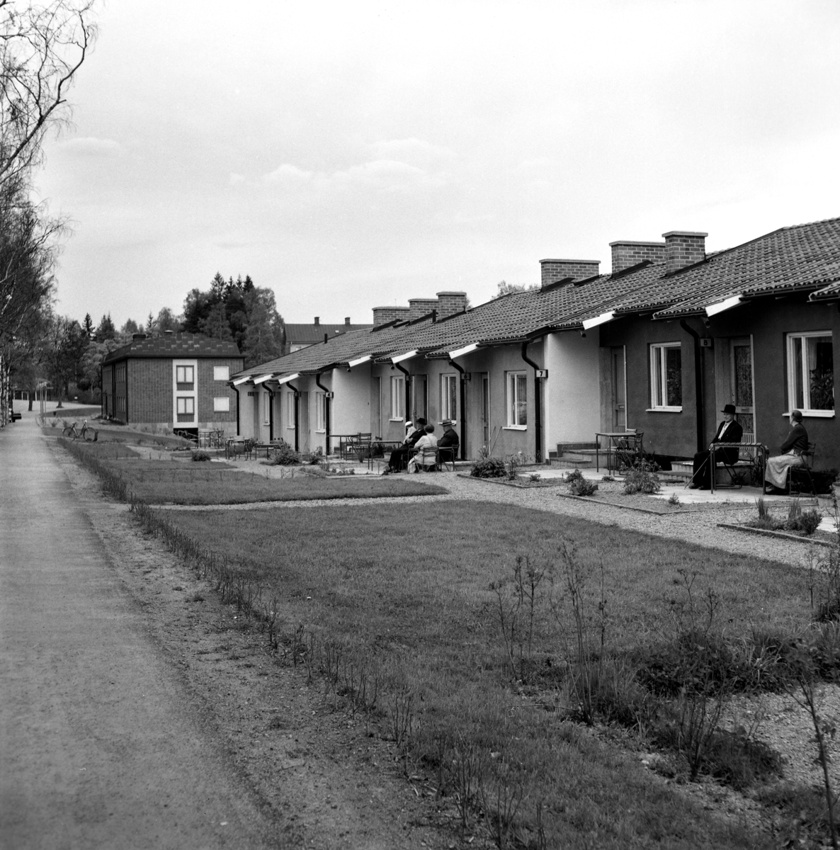 Någonstans i Värmland - från slutet av 1950-talet. Kommentar från användare: "Radhusen vid Stationsgatan i Molkom. I bakgrunden syns tegelhuset som har inrymt bibliotek, polisstation och bank bl.a".
