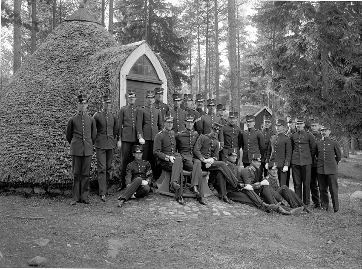 Officersgrupp framför en torvklädd hydda på Kronobergshed, 1927.