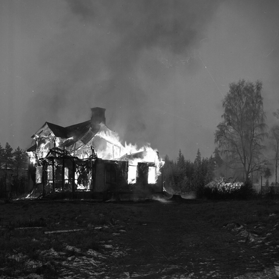 Foto av en brinnande mangårdsbyggnad.