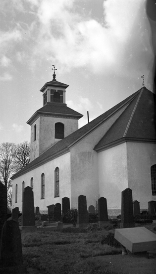 Foto på kyrkan med gravstenar utanför.