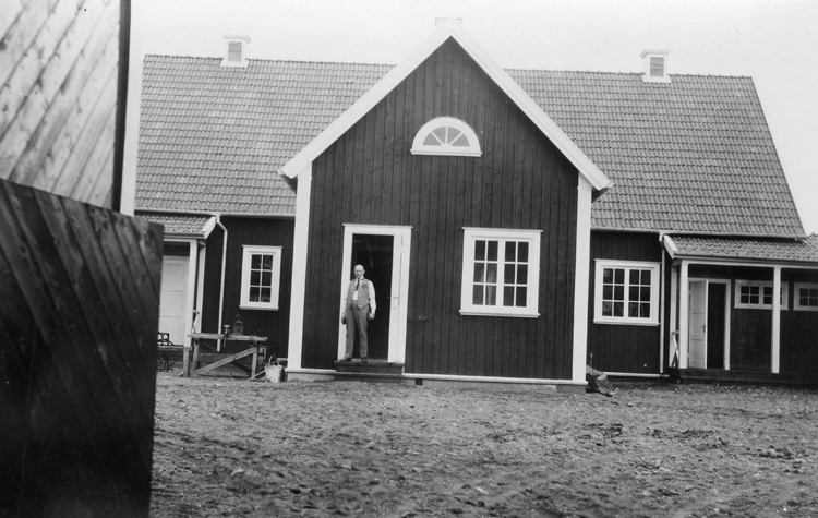 Växjö stads barnkoloni i Skrea, Halland. Innergården med huvudbyggnaden och köket. I köksdörren står en man.