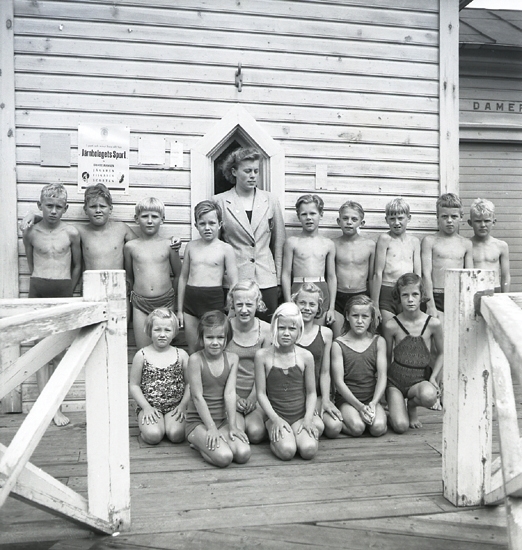 Simningen, 16/8 1942. 
Foto av en barngrupp med ledare, framför badhuset på Evedal.