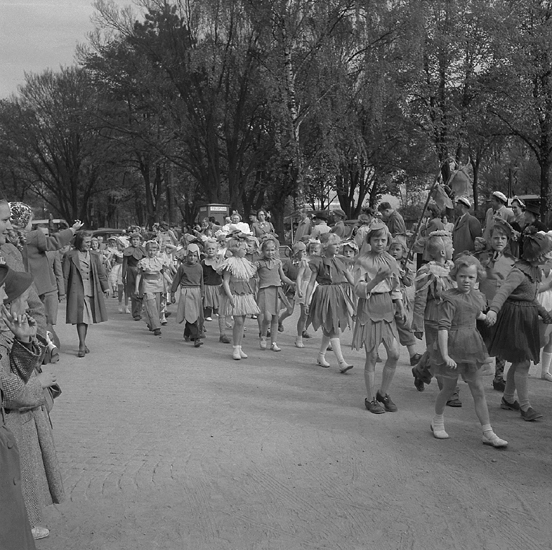 Barnens Dag, 22/5 1952. 
Kortegen. Ett stort antal barn, utklädda till blommor, tågar fram längs  Norra Järnvägsgatan. I bakgrunden syns dåv. Järnvägsparken.