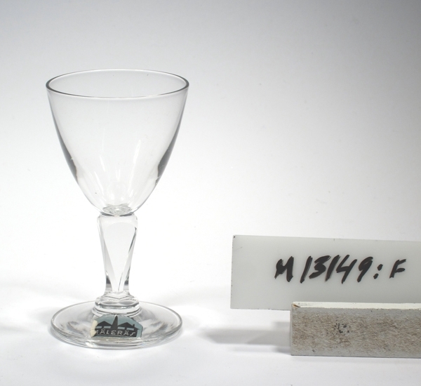 Likörglas "Karat", tillverkat för K.F.
Ritningar av FW/JM 1950 ? (FW = Folke Walwing ?).
Beskrivning: Rund fot, slipat ben.
Färg: Ofärgat klarglas.
Mått: Diameter ovan avser övre diameter. Fotdiameter: 43 mm.
Inskrivet i huvudkatalogen 1943.
Funktion: Likörglas