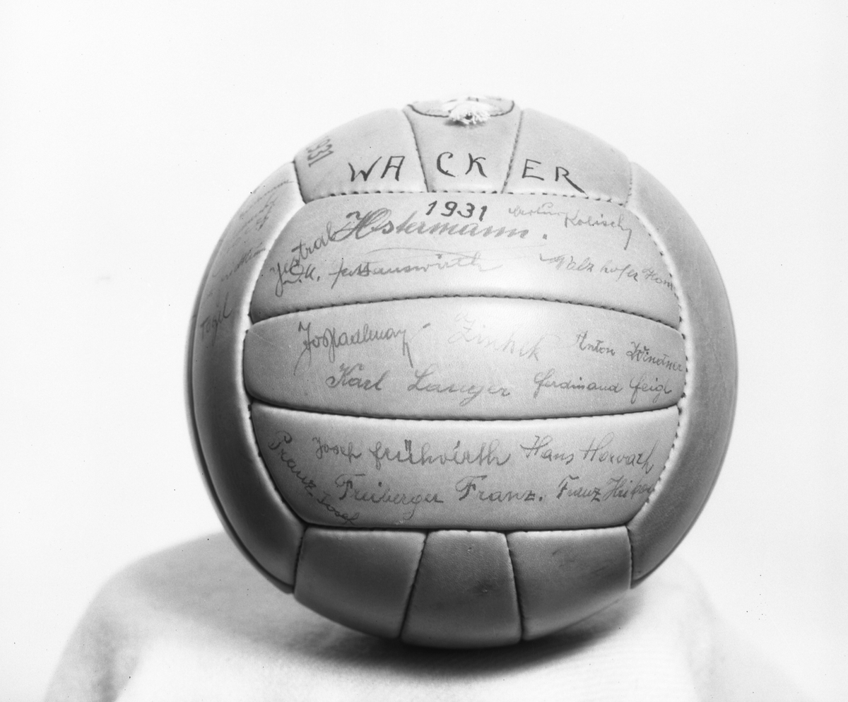 Malmbergs startades 1905 av Elof Malmberg. Blev en av Sveriges ledande producenter av artiklar för idrott, jakt, fiske, skytte och friluftsliv. På bilden en fotboll med texten "Wacker, 1931" och autografer.