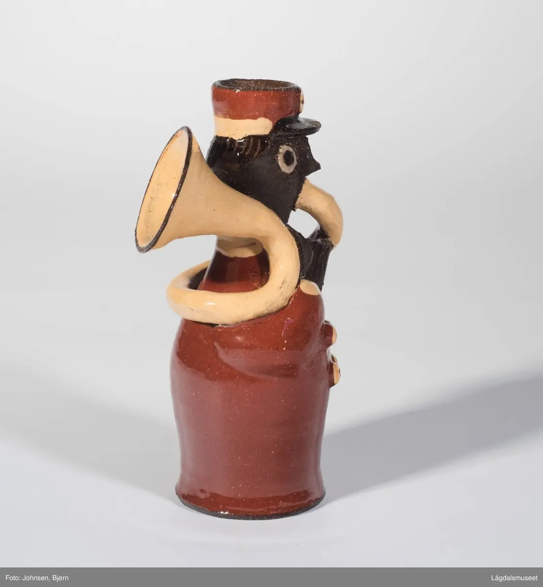 Dekoren på lysestaken utgjør uniformen til musikanten. Utforelsen er en musikant med messinginstrument.