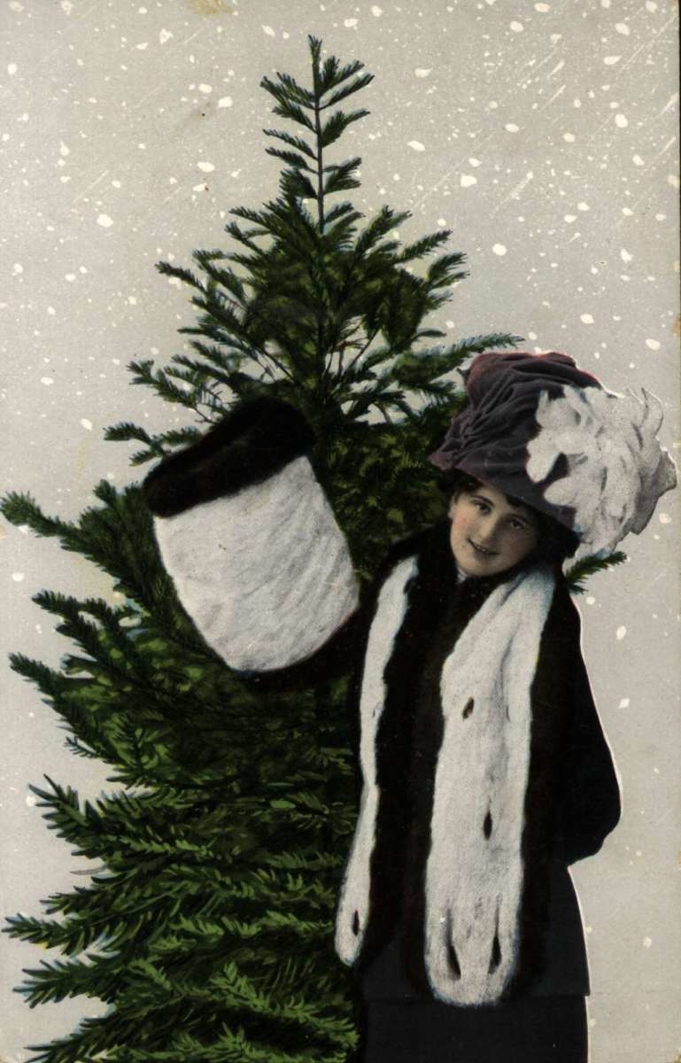 Julekort. Jule- og nyttårshilsen. Kolorert fotografi. Juletre. Kvinne med hatt og muffe.
