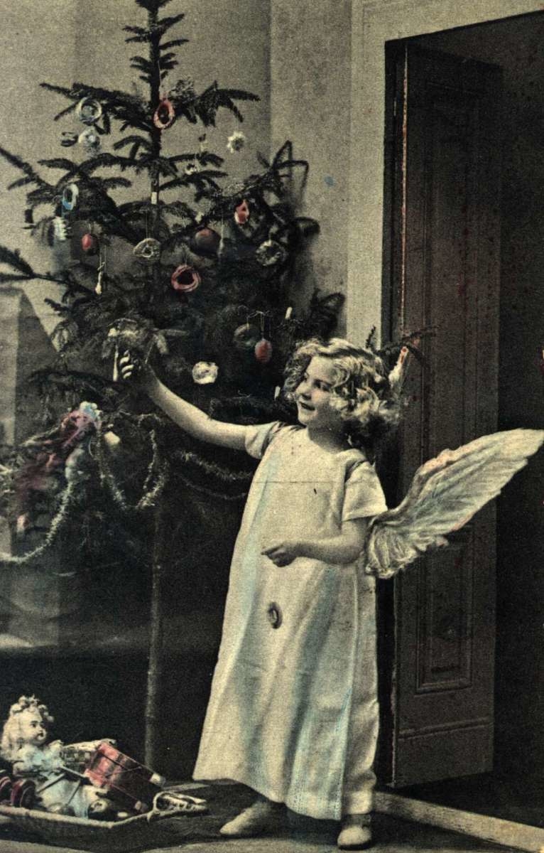 Julekort. Jule- og nyttårshilsen. Kolorert fotografi. Engel foran juletre. Gaver under treet. Stemplet 23.12.1911.