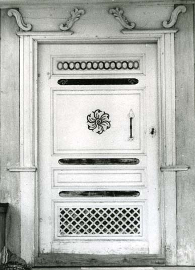 En dörr med målade dekorationer och snidad omfattning.