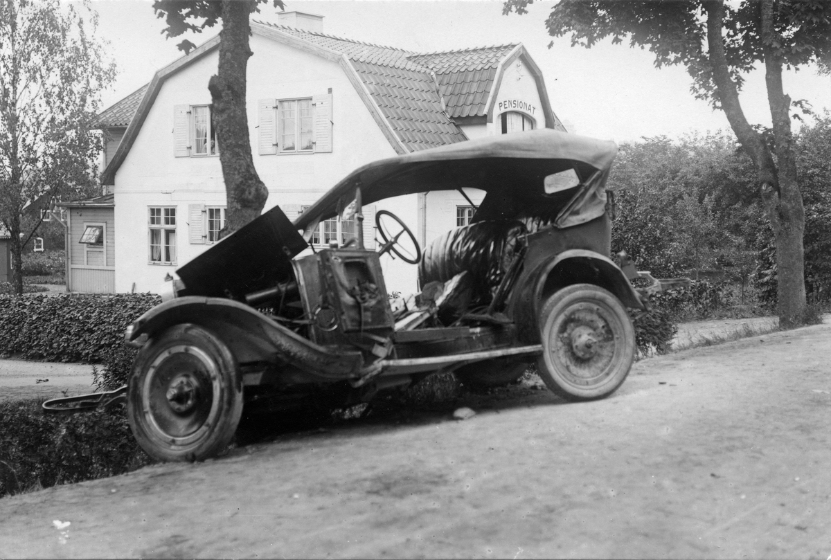 Bil efter krock med träd vid pensionat. Vid folkets park, Köping. Lördag 4 juli 1925.
Oscar Gustavsson ("Kutis") var föraren.
(se även foto KM_82_6270-71 och KM_82_6698)