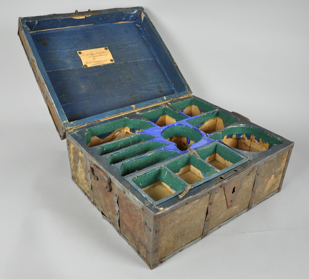 Skrin av tre innfelt med pels, med jernbeslag. Skrinet er seksjonert og innfelt med tøy på innsiden. Skrinet har to hengslede hanker på sidene. Jernbeslaget er rustent, og pelsen på skinnet har falt av på storparten av skrinet. 

Fremstår som i middels god stand.