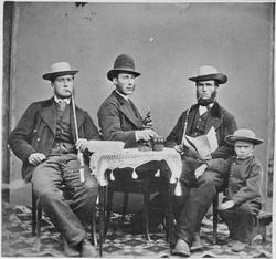 Tre menn med piper og en liten gutt med hatt.