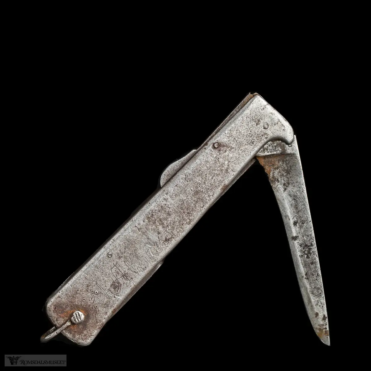 Foldbar tyskprodusert lommekniv. Kniven har to rom, et for hovedknivbladet, og et for en syl og en boksåpner. En liten hempe i metall er naglet fast i bakkant av kniven.