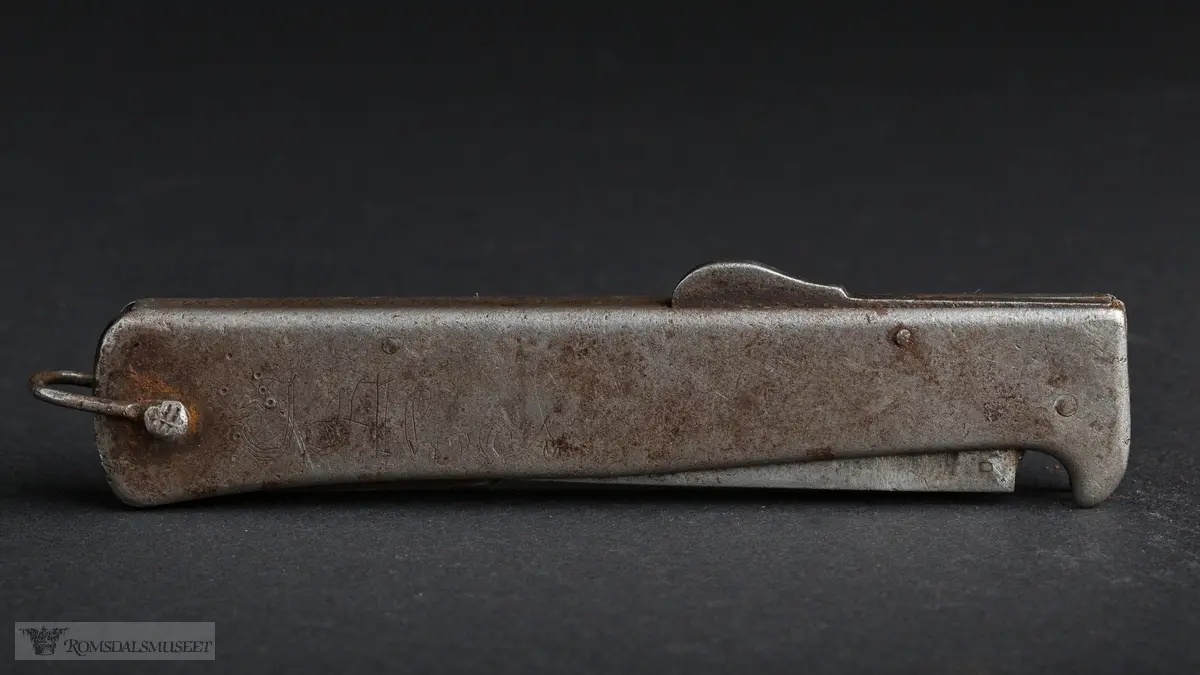Foldbar tyskprodusert lommekniv. Kniven har to rom, et for hovedknivbladet, og et for en syl og en boksåpner. En liten hempe i metall er naglet fast i bakkant av kniven.
