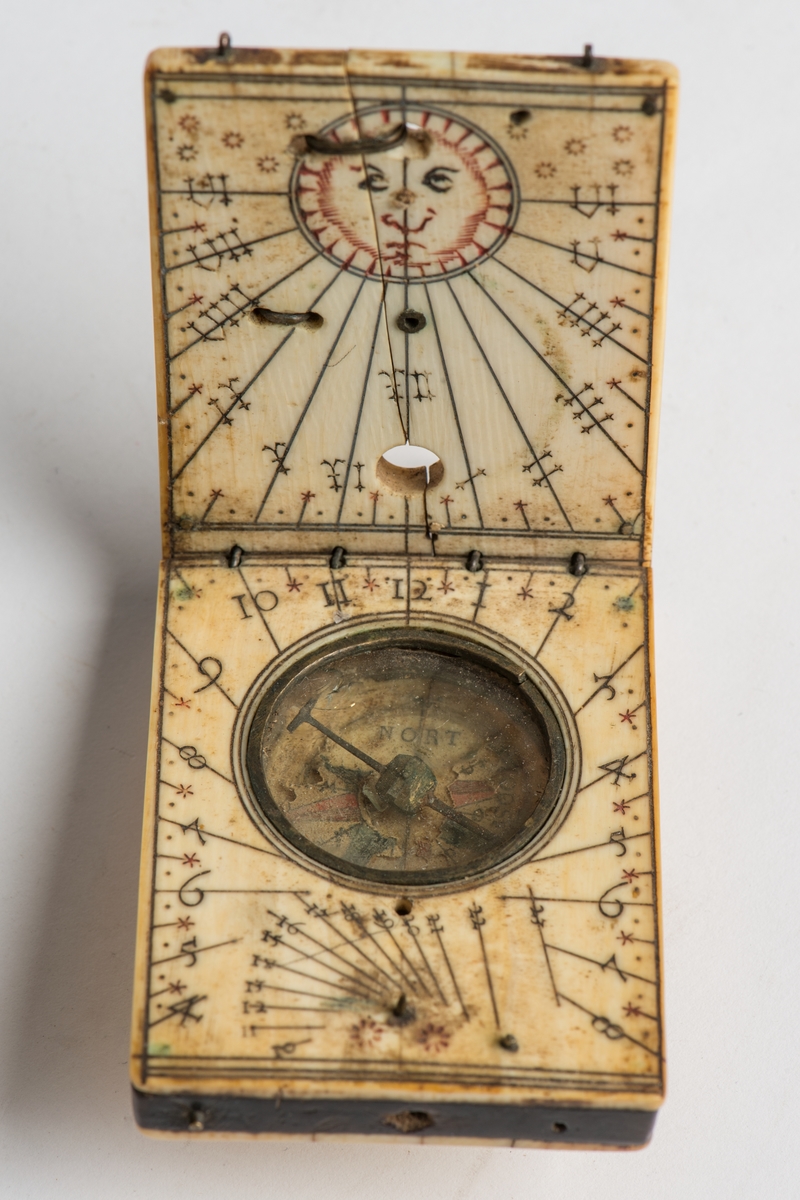 Fickkompass med solur och kompass tillverkat av ben. Fodral i skinn.
