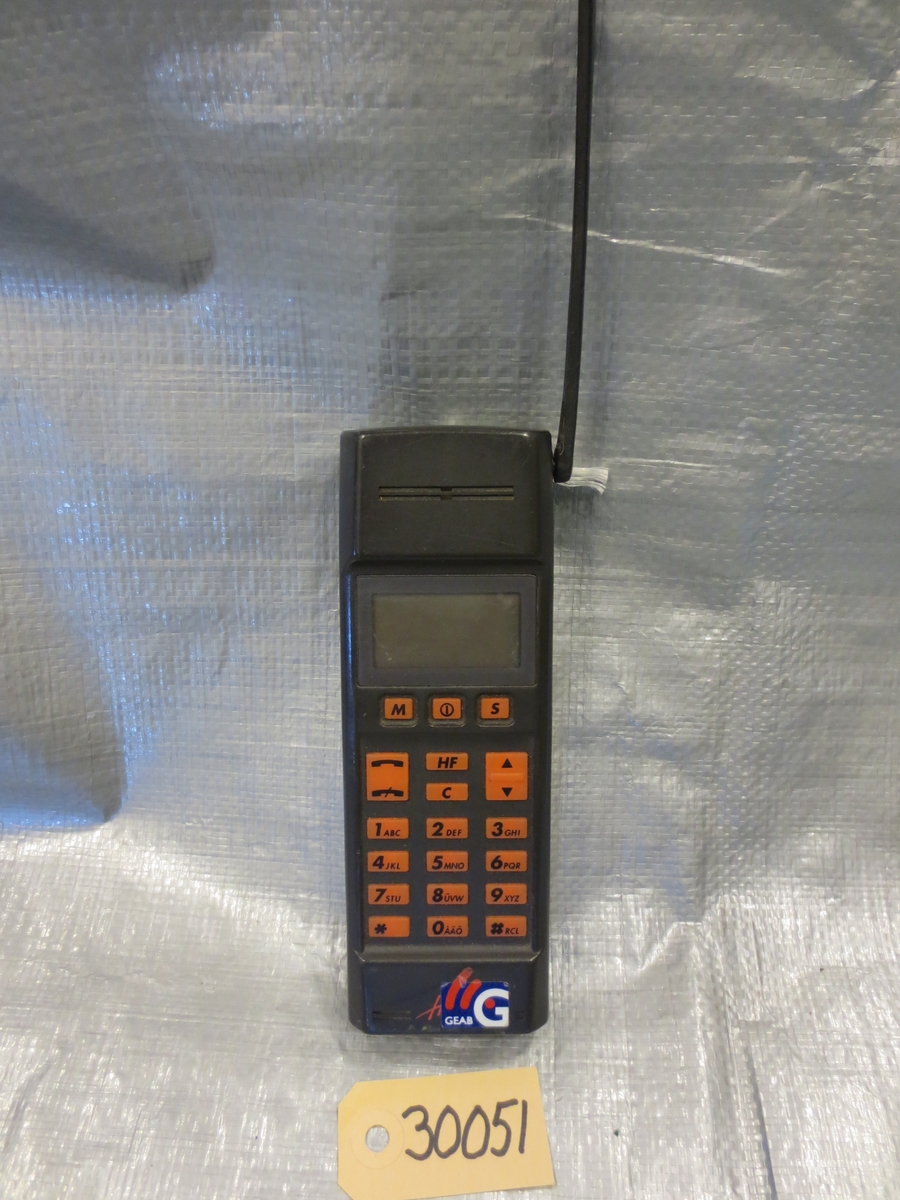 Tidig mobiltelefon i svart plast med uppfällbar antenn
