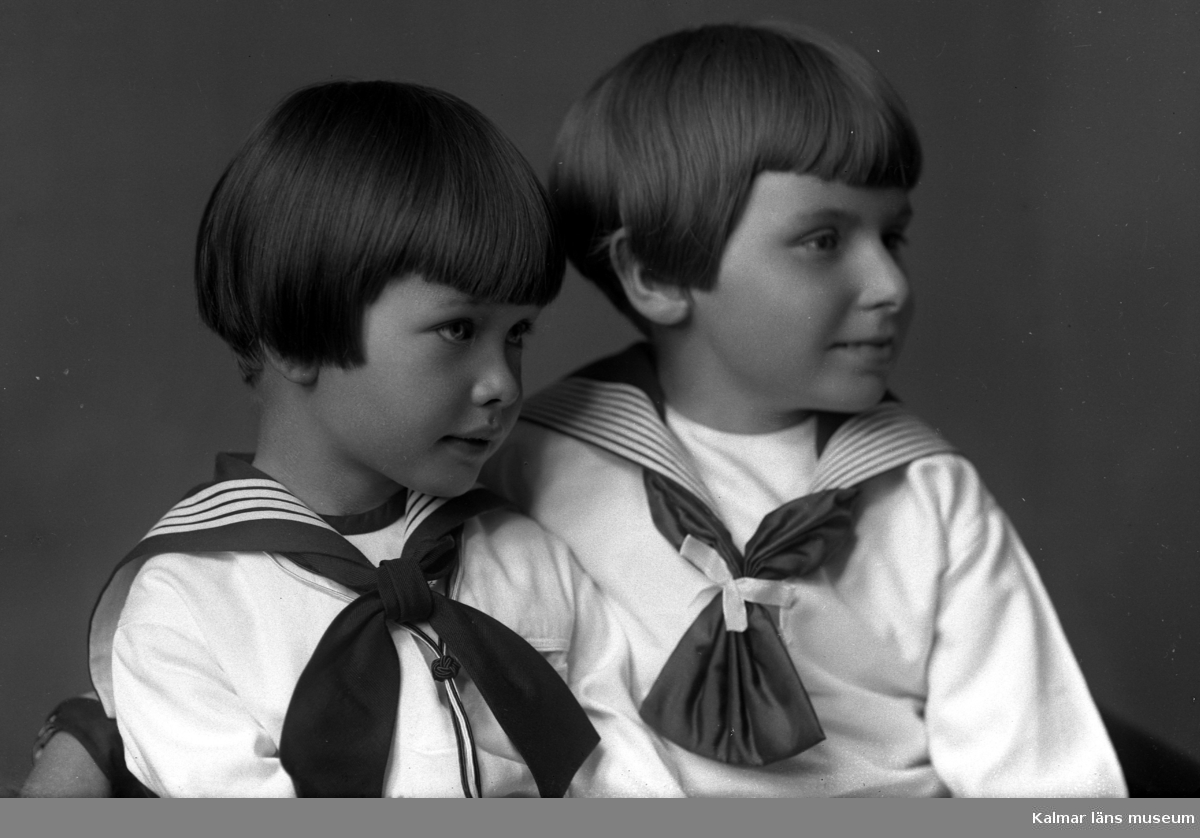 Bild på två flickor i rosetter och sjömansblusar. Enligt Walter Olsons journal är bilden beställd av Fru Gustavsson.