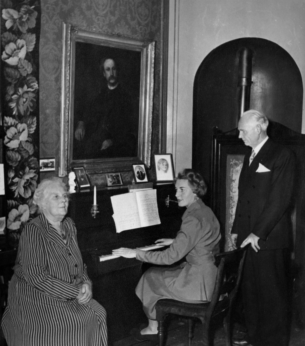 Bilde av etterkommere etter Thomas Tellefsen ved åpningen av musikkhistorisk museum. Over pianoet henger det et portrett av Tellefsen. Børge Friis står til høyre på bildet.