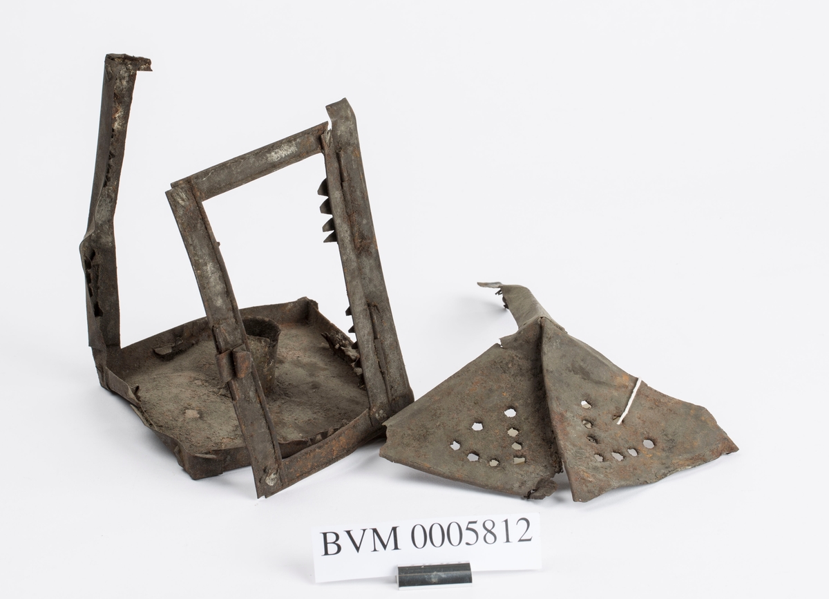 Deler av ei lykt av jern for talglys muligens brukt ved
hestetransport i gruva. Ser holder for laglys. Har hatt dør.
Mulig lysåpningene har vært dekket med med vom, tarm eller
lignende. Består av to deler som har falt fra hverandre.