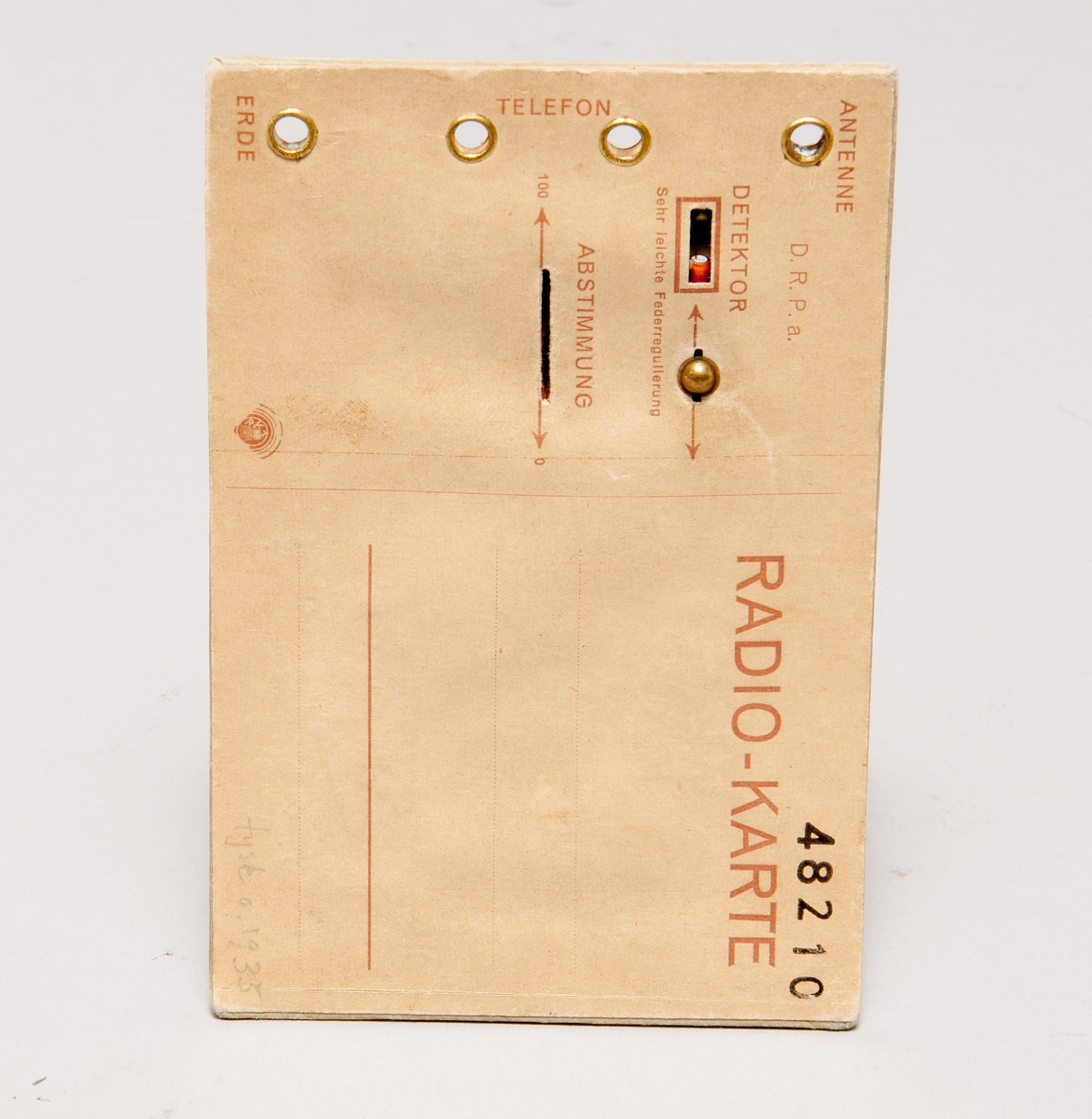 Kristallmottagare i form av vykort, med uttag för antenn, jord, hörtelefon. Kortet har påskriften "Der ist drollig!" samt inställningsmöjligheter för detektor och avstämning.
