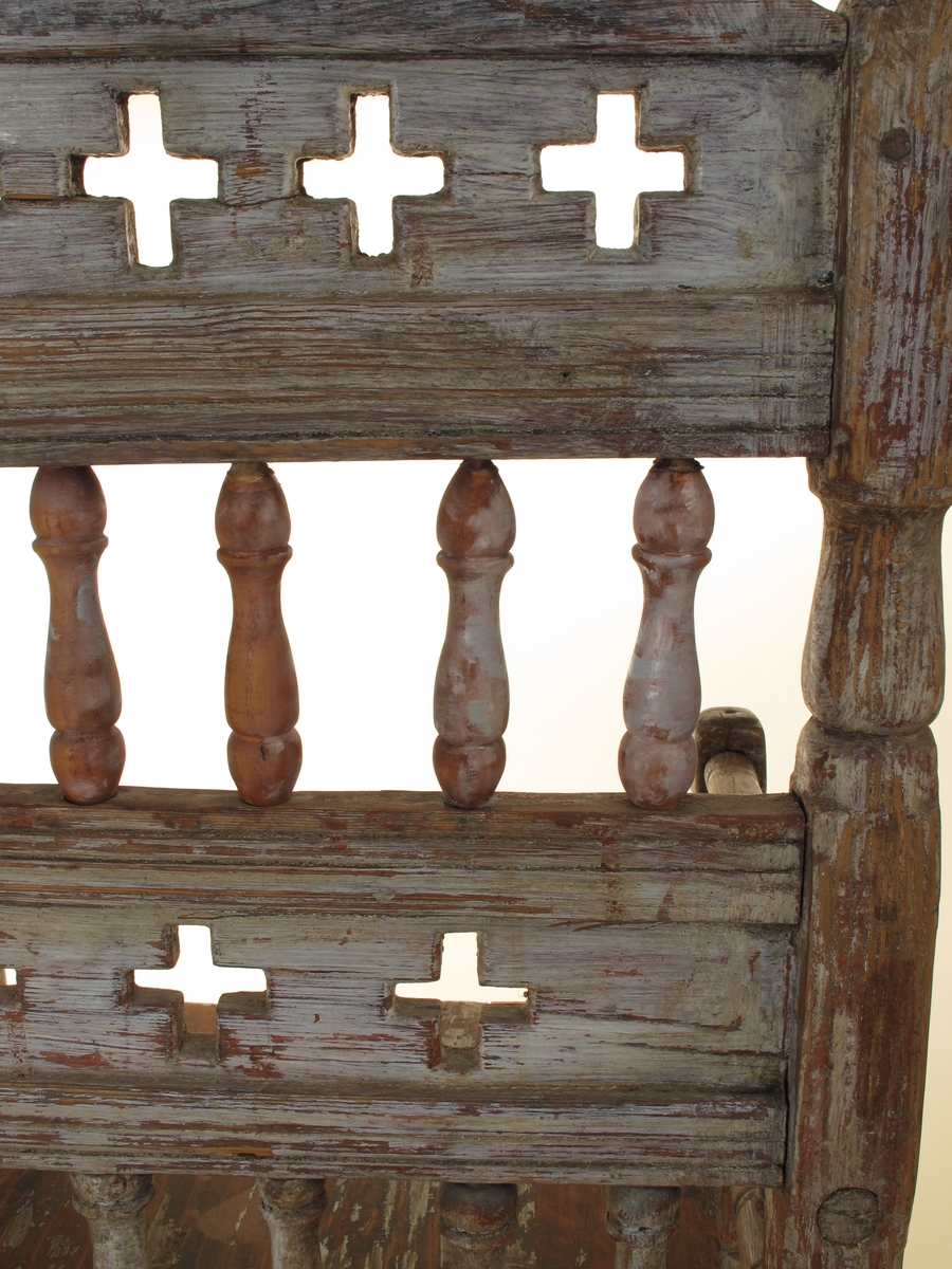 Senmiddelaldersk type, av dreiede pinner. Muligens opprinnelig kirkestol, da der er rader med kors i ryggen. Armlenene har på undersiden festet 6 små  balustre, som nedentil er festet i nok en dreiet tverrligger. Der har likeledes vært balustre (3 stk) under sargen i fronten ned til den øvre tverrstreber. Ryggen består av avvekslende dreiede balustre i tett  rad og horisontale bretter med utskårne gjennombrutte kors. Buet toppstykke. Endene av bakstavene har dreide knotter.