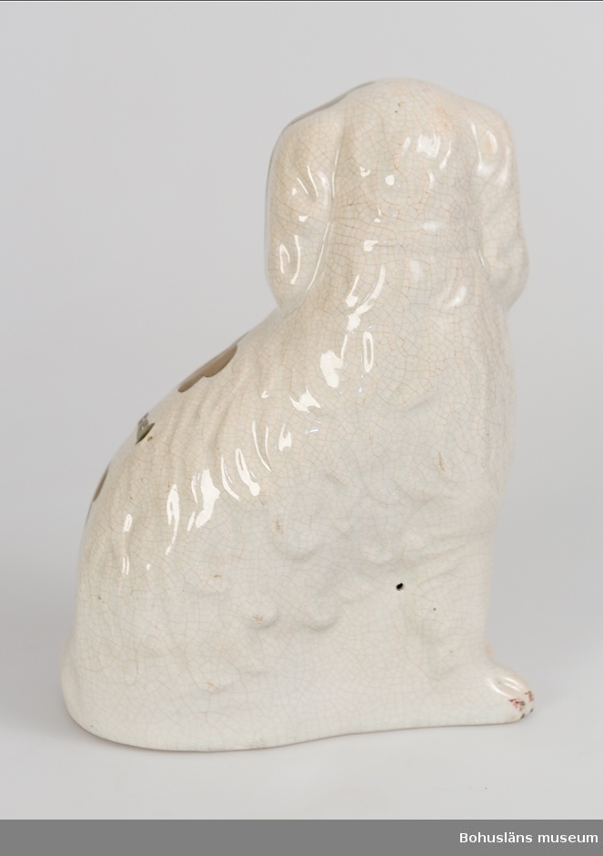 Sammanhör med UM004695

Ur handskrivna katalogen 1957-1958:
Hund av porslin (sittande)
Föremålet av vitt porslin, delvis bronserat. Smärre sprickor på ytan. För övrigt hel.