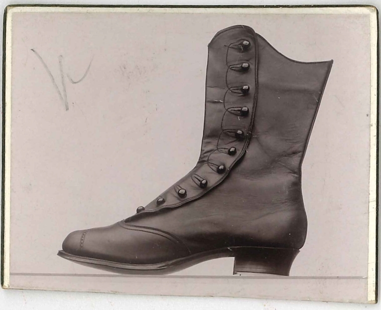 Fotografi av ett skodon. Damkänga med knäppning.

Använd som reklam på A F Carlssons skofabrik.

Ingår i en samling med 123 stycken kort i kartong.