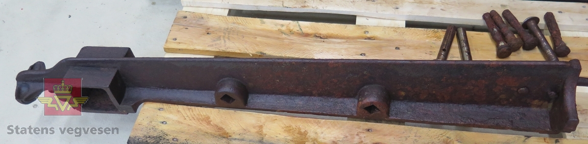 Stolpe, sju bolter og tverrstag til bruk mellom to stolper. Av jern.